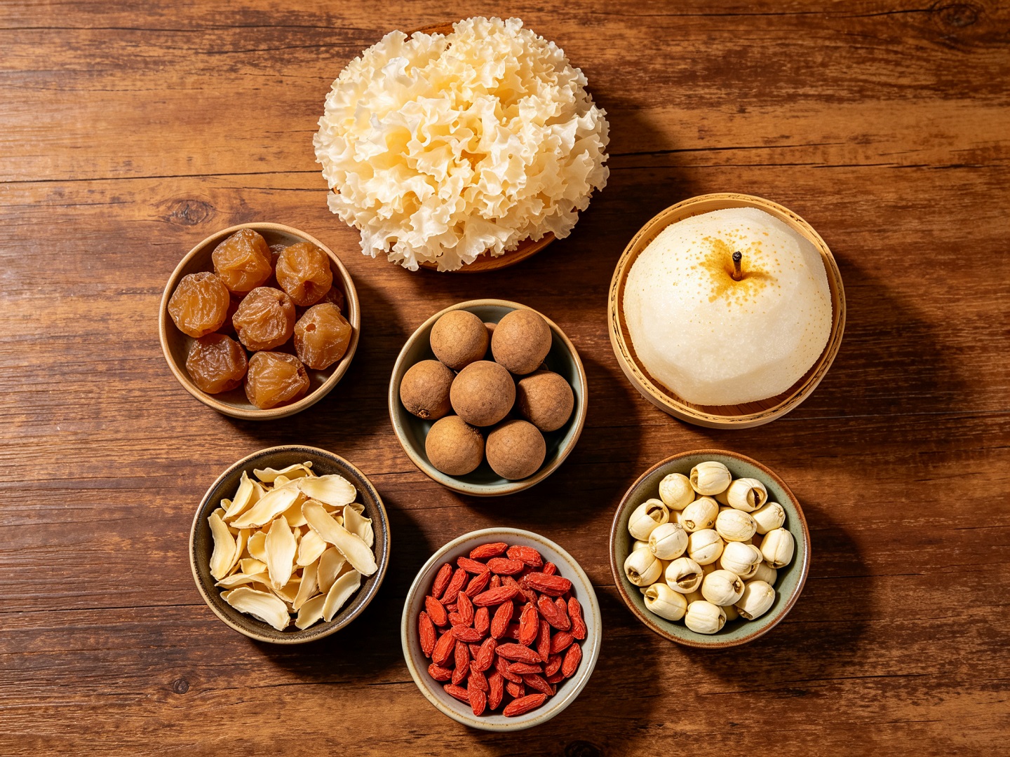 Flat lay of longan tremella soup ingredients — dried white fungus, snow pear, longan, lily bulbs and goji berries